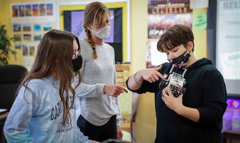 Teacher helps student with robot LEGO
